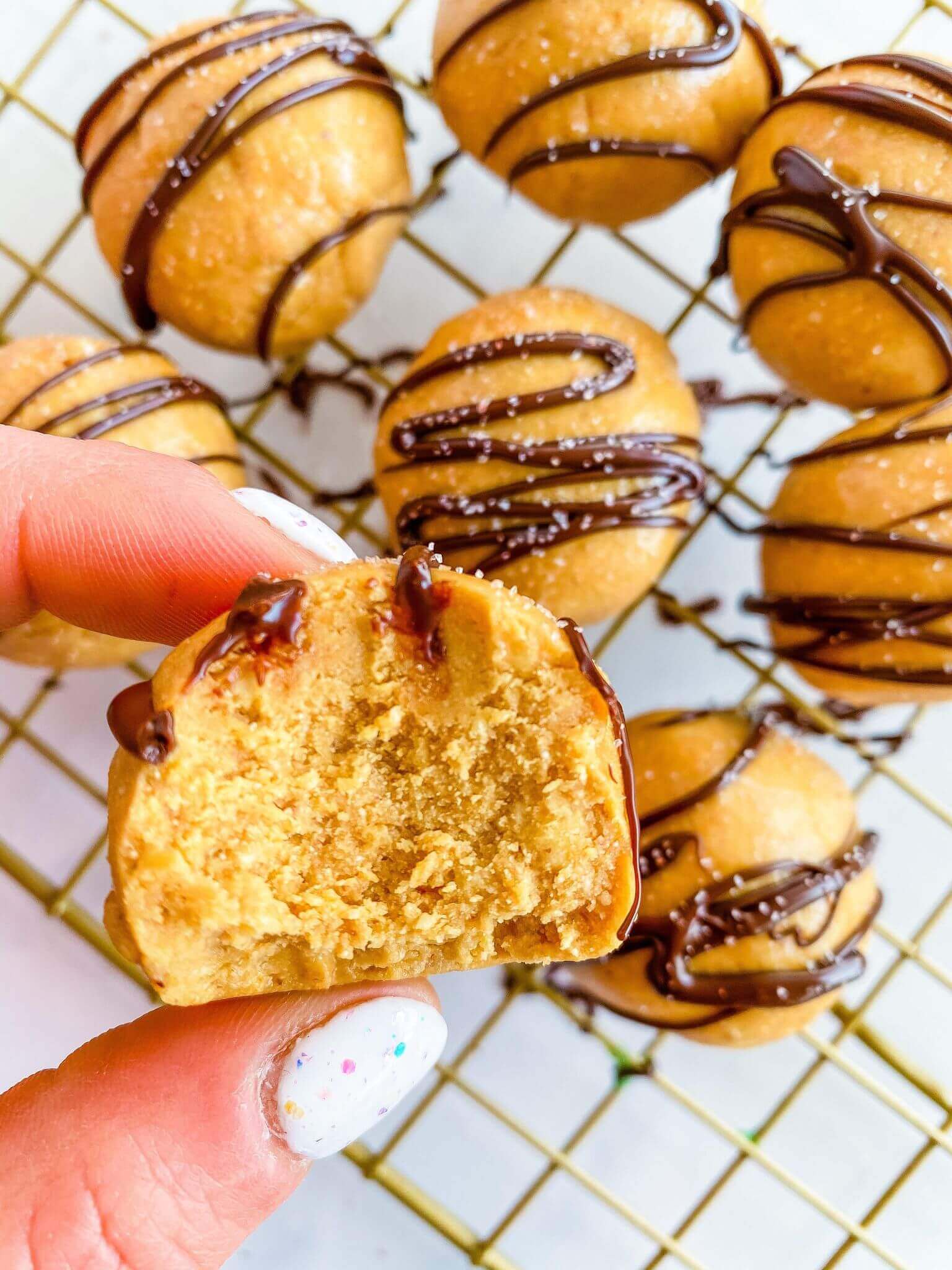 Peanut Butter Collagen Chocolate Bites | Holding it with fingers and bite is taken out of it